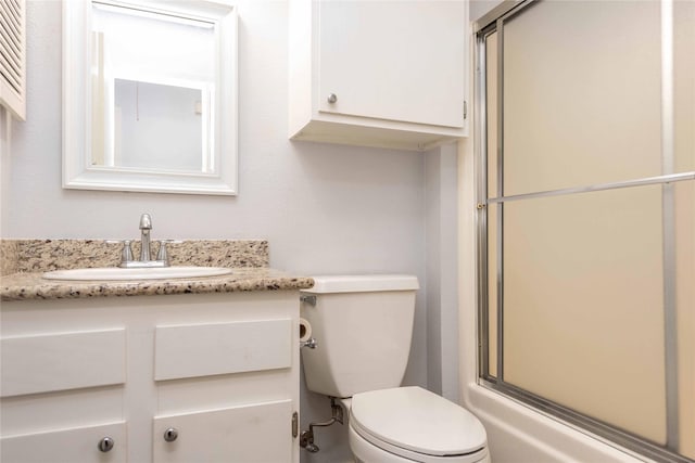 full bathroom featuring shower / bath combination with glass door, vanity, and toilet