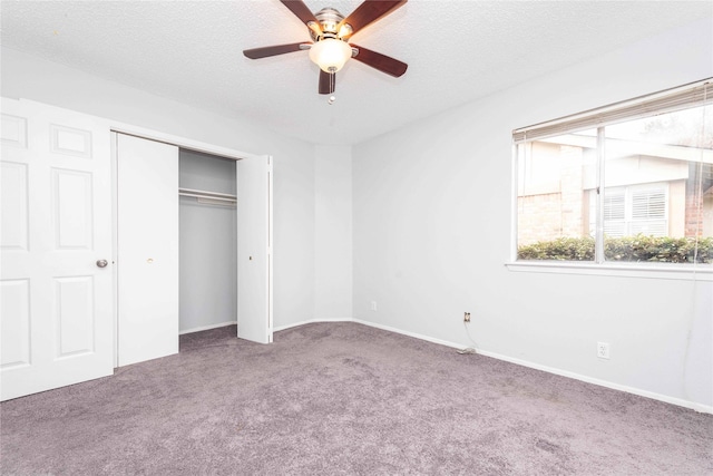 unfurnished bedroom with a textured ceiling, a closet, ceiling fan, and carpet flooring