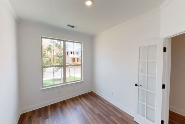 spare room featuring ornamental molding and dark hardwood / wood-style flooring