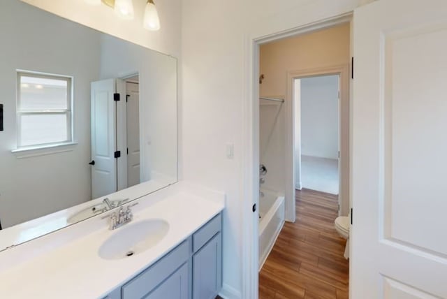 full bathroom featuring vanity, toilet, hardwood / wood-style flooring, and tub / shower combination