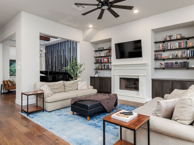 living room featuring hardwood / wood-style floors, built in features, and ceiling fan