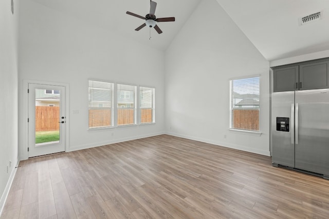 unfurnished living room with light wood-type flooring, high vaulted ceiling, and ceiling fan