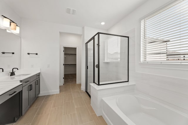 bathroom featuring plus walk in shower, vanity, and tile patterned floors