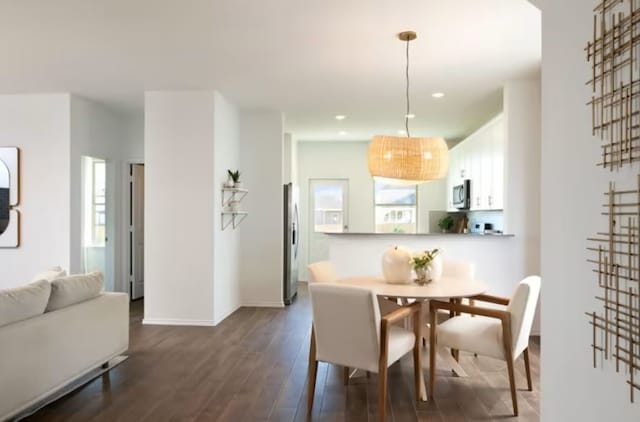 dining space with plenty of natural light and dark hardwood / wood-style flooring