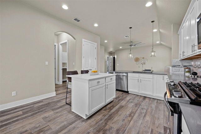 kitchen with white cabinets, stainless steel appliances, pendant lighting, and a kitchen island