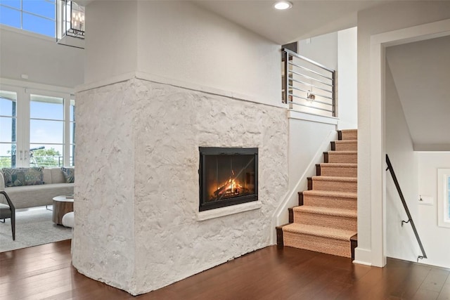 staircase with a fireplace, hardwood / wood-style flooring, and a wealth of natural light