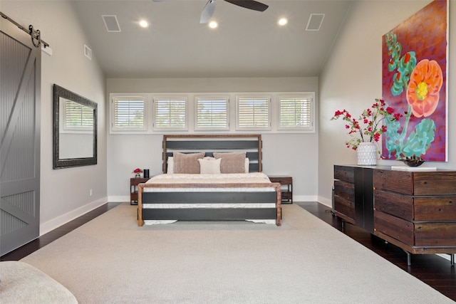 bedroom featuring lofted ceiling, a barn door, ceiling fan, and dark wood-type flooring