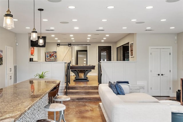 living area featuring recessed lighting, a barn door, and visible vents