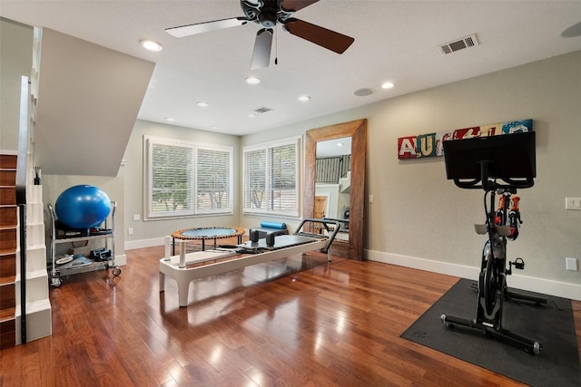 exercise area with visible vents, baseboards, ceiling fan, and wood finished floors