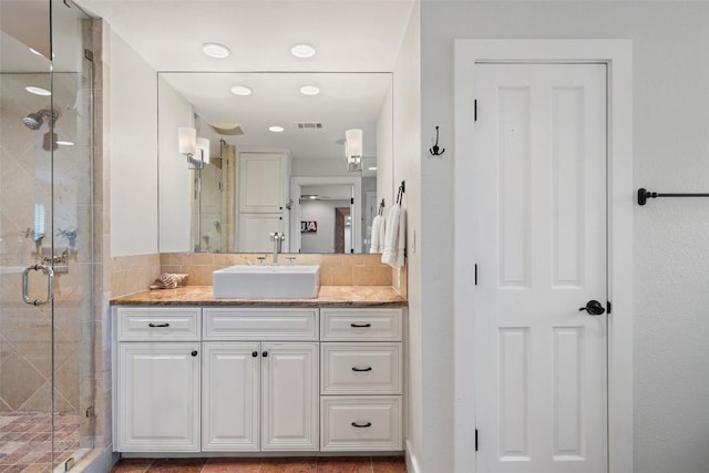 full bathroom with vanity, decorative backsplash, and a stall shower