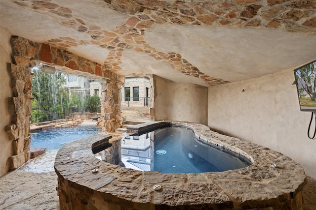 view of swimming pool featuring a hot tub