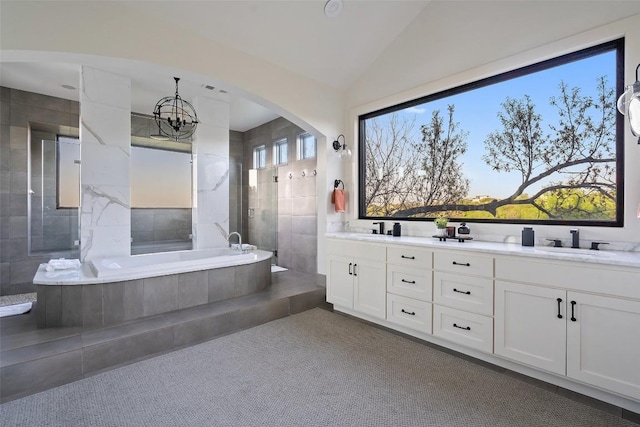 full bathroom with double vanity, a garden tub, vaulted ceiling, a sink, and tiled shower