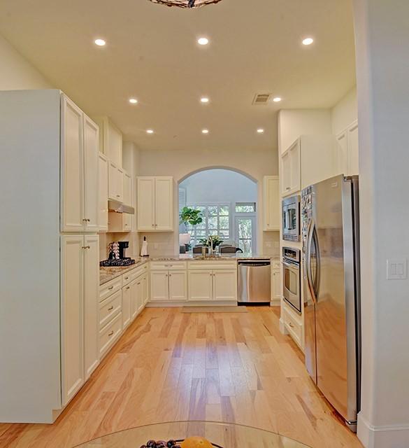 7800 SW Pkwy Unit 510, Austin, TX 78735 - kitchen featuring stainless steel appliances, arched walkways, light wood-type flooring, recessed lighting, and under cabinet range hood