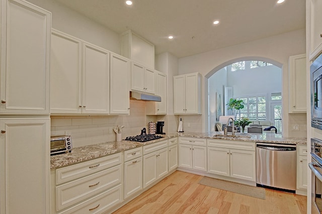 kitchen with tasteful backsplash, black gas cooktop, light wood-type flooring, sink, and dishwasher