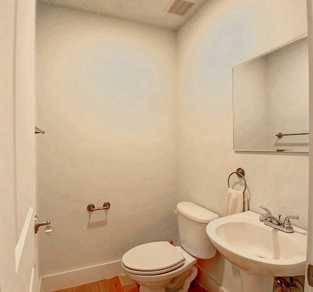 bathroom with hardwood / wood-style floors, sink, and toilet