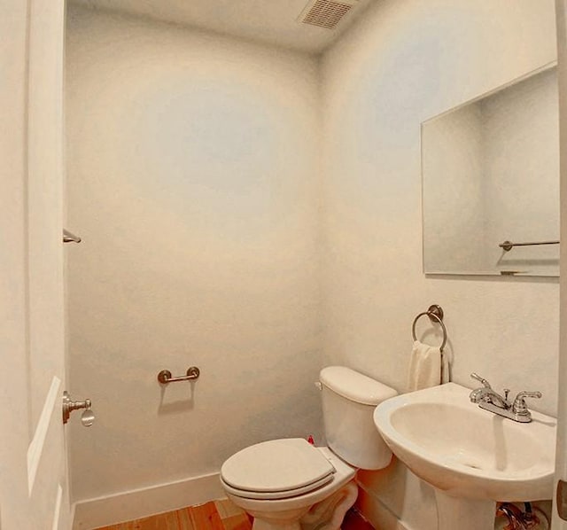 7800 SW Pkwy Unit 510, Austin, TX 78735 - bathroom featuring a sink, wood finished floors, toilet, and baseboards