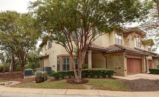 view of front of house featuring a garage and central AC