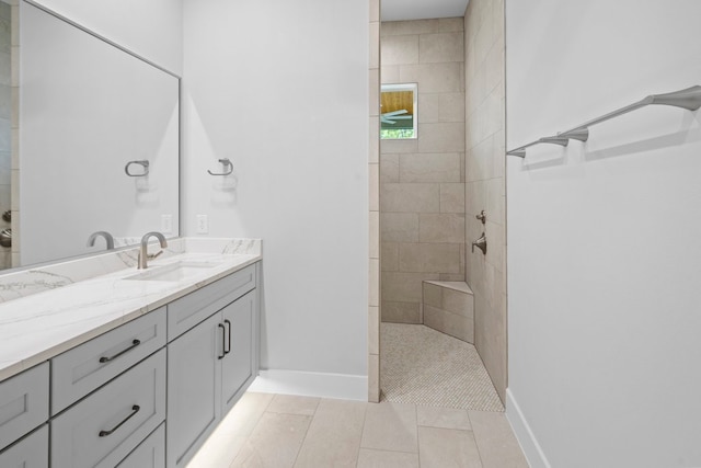 bathroom with vanity, tiled shower, and tile patterned floors