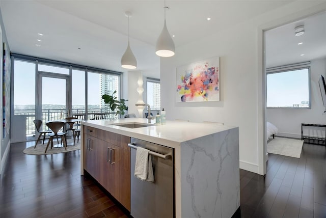 kitchen with dishwasher, dark wood-type flooring, sink, pendant lighting, and a wall of windows