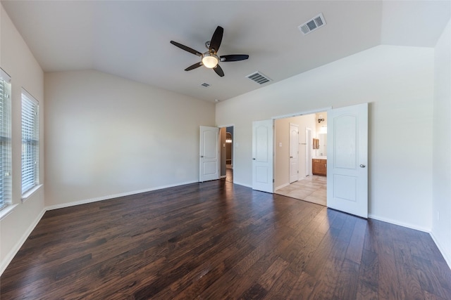 unfurnished bedroom with ensuite bathroom, vaulted ceiling, wood-type flooring, and ceiling fan