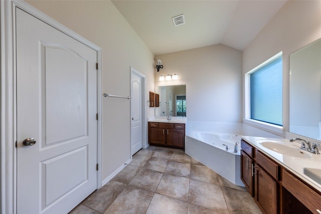 bathroom featuring vanity, tile patterned flooring, lofted ceiling, and a washtub