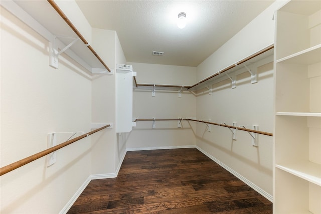 spacious closet with dark hardwood / wood-style flooring