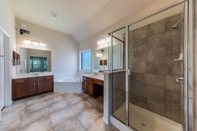 bathroom featuring vanity, vaulted ceiling, separate shower and tub, and tile patterned flooring