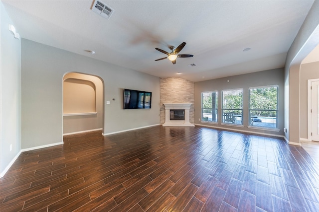 unfurnished living room with a textured ceiling, ceiling fan, a fireplace, and dark hardwood / wood-style flooring