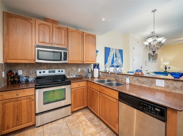 kitchen featuring backsplash, sink, a notable chandelier, decorative light fixtures, and appliances with stainless steel finishes