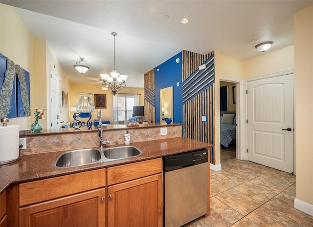 kitchen featuring a chandelier, dark stone counters, dishwasher, decorative light fixtures, and sink