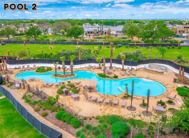 view of swimming pool with a jacuzzi, a patio area, and a lawn