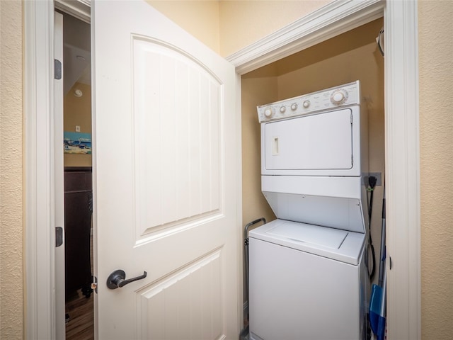 clothes washing area with stacked washer and clothes dryer