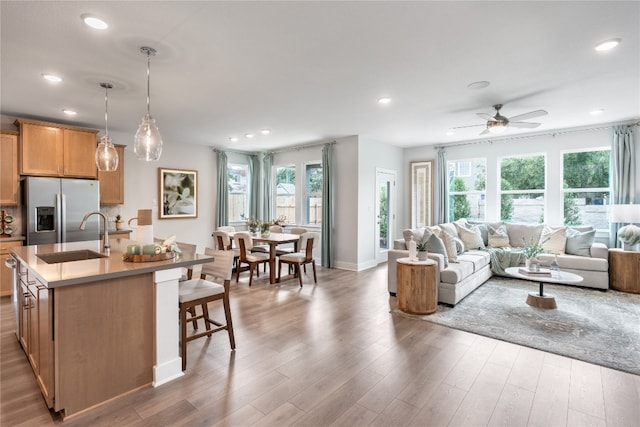 living room featuring sink, ceiling fan, hardwood / wood-style flooring, and plenty of natural light