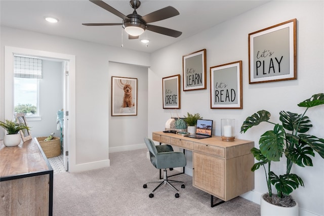 home office featuring light carpet and ceiling fan