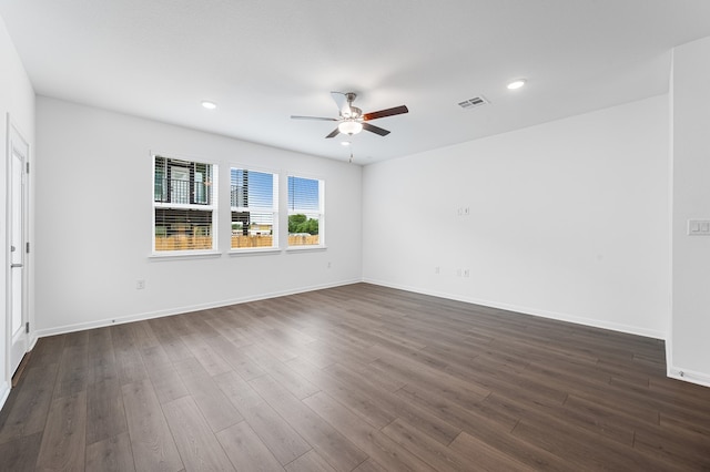 spare room with a ceiling fan, visible vents, baseboards, dark wood-style floors, and recessed lighting