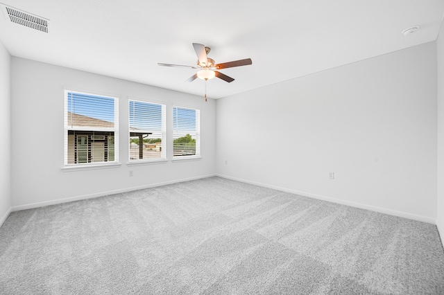 empty room with ceiling fan, visible vents, baseboards, and carpet