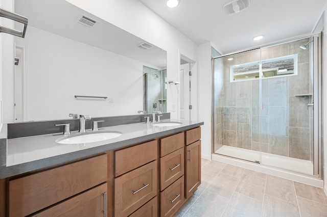 bathroom with double vanity, visible vents, a sink, and a stall shower