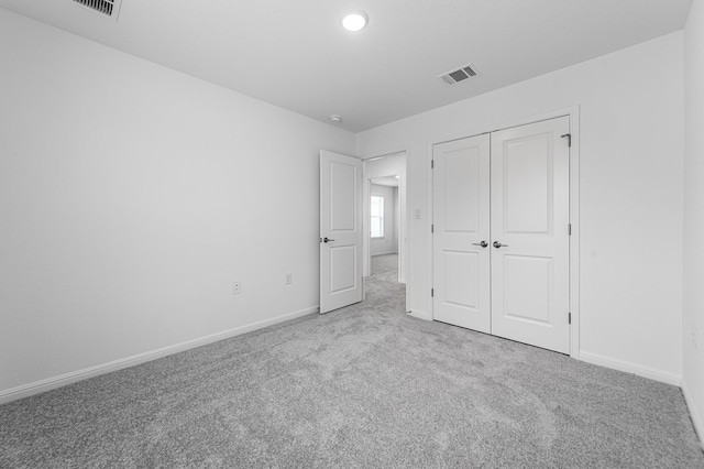 unfurnished bedroom featuring visible vents, carpet flooring, baseboards, and a closet