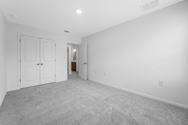 unfurnished bedroom with baseboards, visible vents, and carpet
