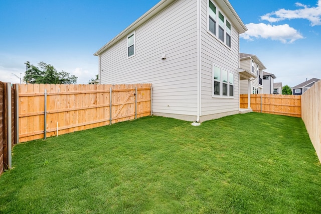 rear view of property featuring a lawn and a fenced backyard