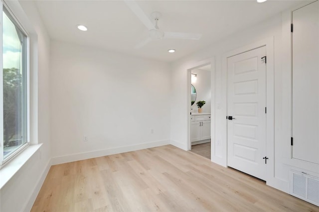 unfurnished bedroom featuring ensuite bathroom, ceiling fan, and light hardwood / wood-style floors