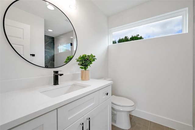 bathroom featuring vanity, a healthy amount of sunlight, toilet, and a shower with shower door