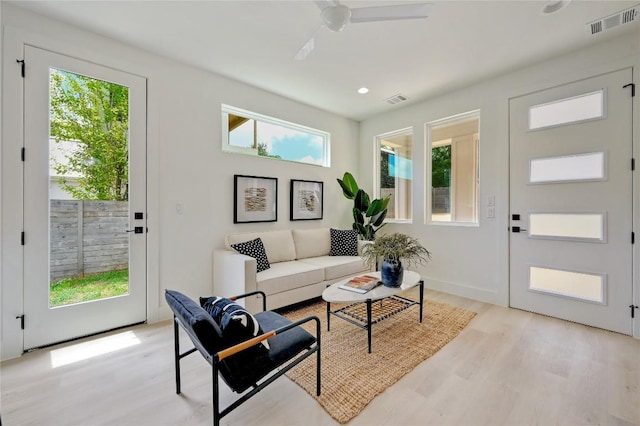 living room featuring light hardwood / wood-style flooring and ceiling fan