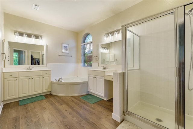 bathroom with vanity, plus walk in shower, and hardwood / wood-style flooring