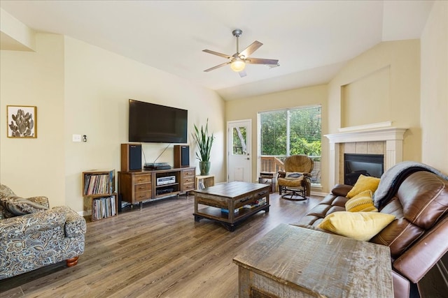 living room featuring ceiling fan, wood-type flooring, lofted ceiling, and a fireplace