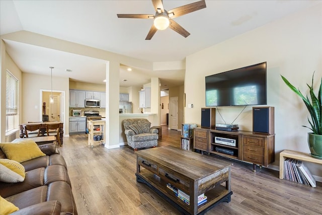 living room with ceiling fan, hardwood / wood-style flooring, lofted ceiling, and plenty of natural light