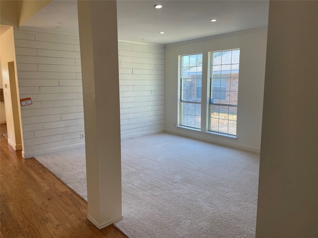 spare room with crown molding and light wood-type flooring