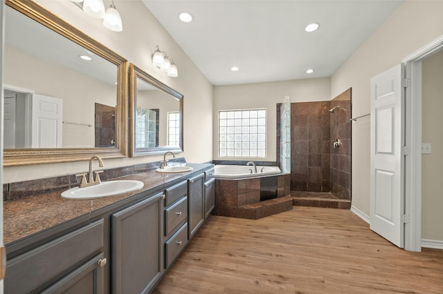 bathroom with vanity, hardwood / wood-style floors, and plus walk in shower