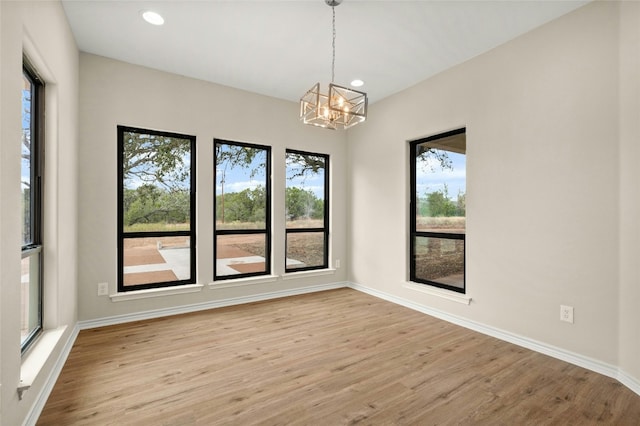 unfurnished room featuring light hardwood / wood-style flooring and a notable chandelier