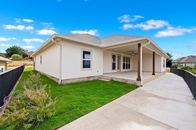 rear view of property featuring a patio, ceiling fan, and a lawn